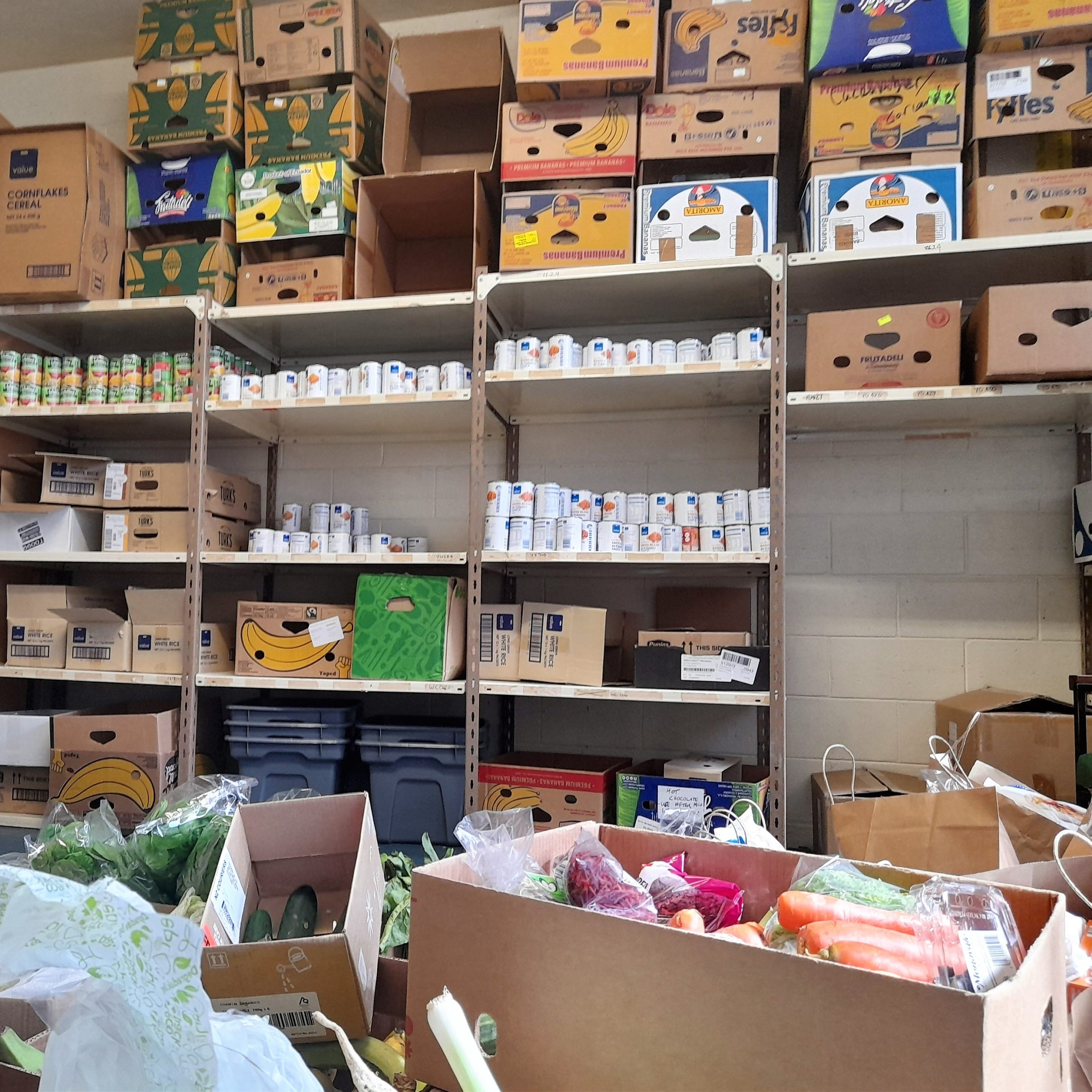 Foodbank shelves and boxes of food.